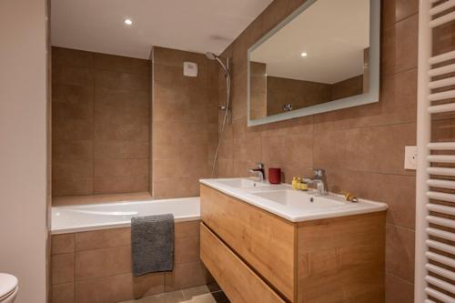 une salle de bain avec une baignoire et un lavabo et une baignoire dans l'établissement Le Solaret B207, aux Gets