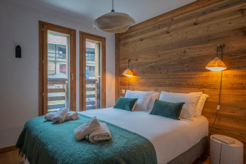 une chambre avec un grand lit avec des serviettes dessus dans l'établissement Le Solaret B207, aux Gets