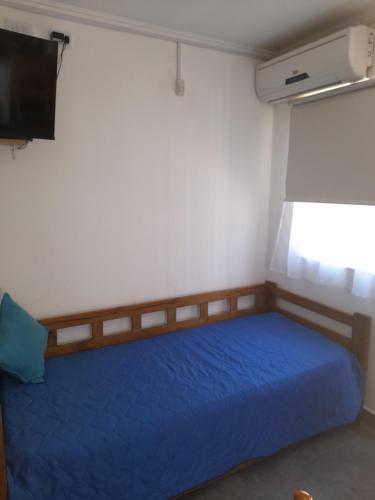 a bedroom with a blue bed and a television at Monoambiente Claro de Luz in Federación