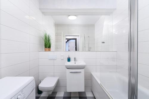 une salle de bains blanche avec toilettes et lavabo dans l'établissement A.S. HOME Kosciuszki, à Wrocław