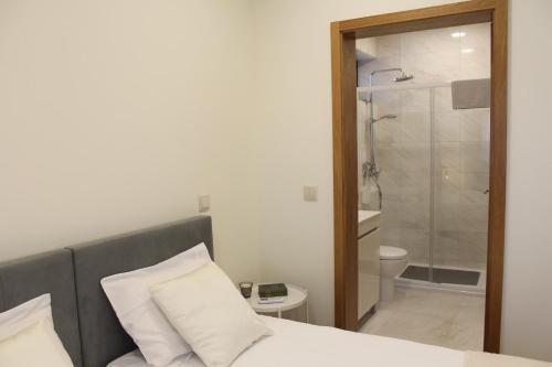 a bedroom with a bed and a bathroom with a shower at Casa dos Amigos - Arouca in Arouca
