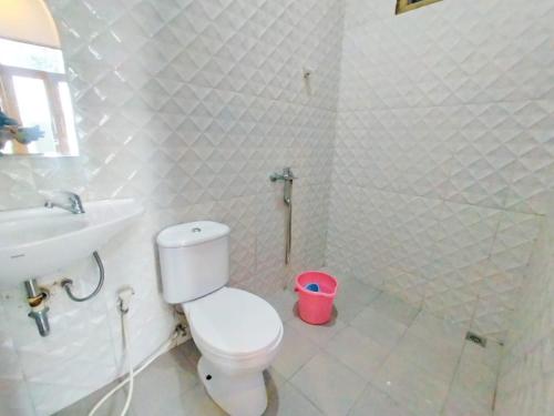ein weißes Bad mit einem WC und einem Waschbecken in der Unterkunft Villa Cisarua Zeni 1 in Brujul