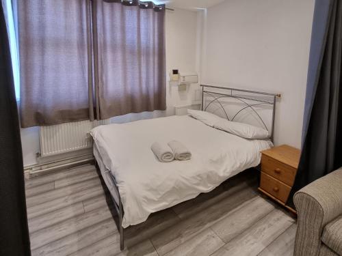 a bedroom with a bed with white sheets and a window at Entire Flat with Three Bedrooms N 2 in Great Yarmouth