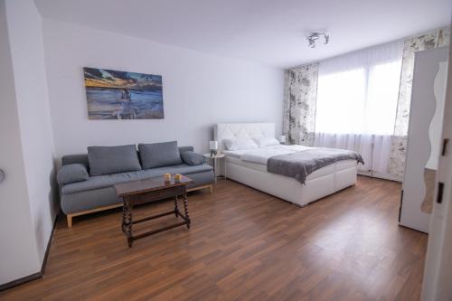 - un salon avec un lit et un canapé dans l'établissement Southern Living by JR City Apartments - Visit Vienna & shop in Vösendorf, à Vienne