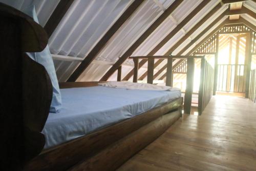 a bed in a attic with a wooden floor at Green Cloud Villa in Ella