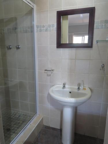 a bathroom with a sink and a shower at Orchard Guesthouse in Bloemfontein