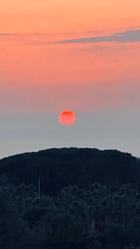 a red sun in the sky at sunset at B&B Casale Pietrantica Tropea in Ciaramiti