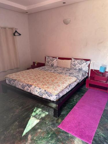 a bedroom with a bed with a pink rug at Villa Ms Holidays Mika privatisée Marrakech in Marrakech