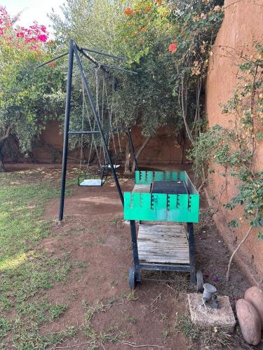 a green swing set sitting in a yard at Villa Ms Holidays Mika privatisée Marrakech in Marrakech