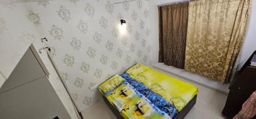 een kleine kamer met een geel bed in de hoek bij La Grandiose Luxury Serviced Apartments in Bangalore