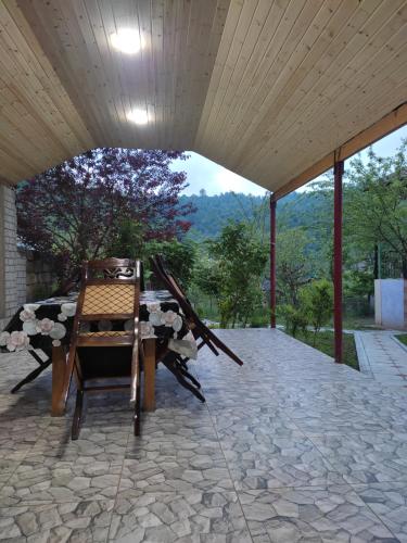un patio con mesa y sillas bajo un techo en Lerik Renthouse, en Lerik