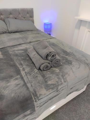 a bed with a blanket on top of it at Moden Stylish large Southsea Apartment with jacuzzi bath sleeps 6 in Portsmouth