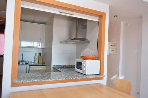 a kitchen with a microwave on a counter at Apartamento Altafulla in Altafulla