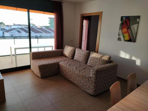 a living room with a couch and a large window at Apartamento Altafulla in Altafulla