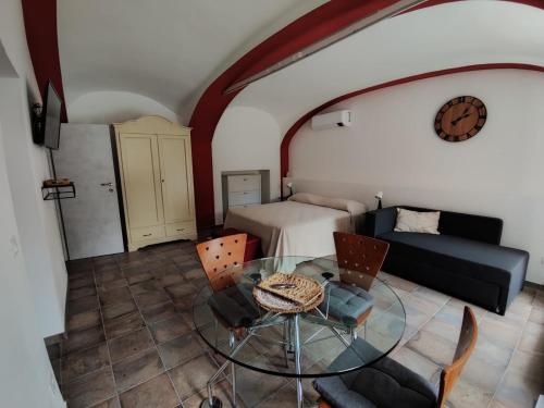ein Wohnzimmer mit einem Glastisch und einem Bett in der Unterkunft Ninsòle in La Morra