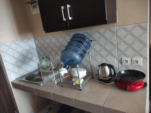 a kitchen counter with a sink and a blue pot at Apartemen Msquare Cibaduyut 23 m studio in Bandung
