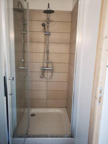 une douche avec une porte vitrée dans une salle de bain dans l'établissement T2 - Appartement 1 chbre Wissant, à Wissant