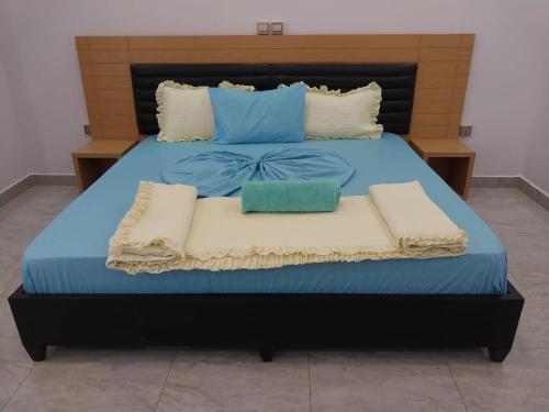 a large bed with blue sheets and pillows on it at KANOMBE AIRPORT BED& BREAKFAST in Kigali