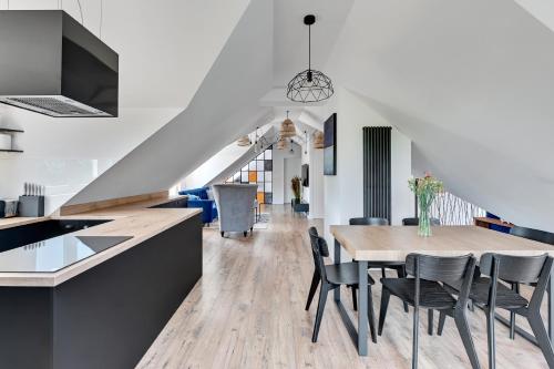 kuchnia i jadalnia ze stołem i krzesłami w obiekcie ZMYSŁY MORZA - Apartament Architektów Gdynia Orłowo w mieście Gdynia