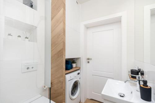 a white laundry room with a washer and dryer at BlueApart Mogilska in Kraków