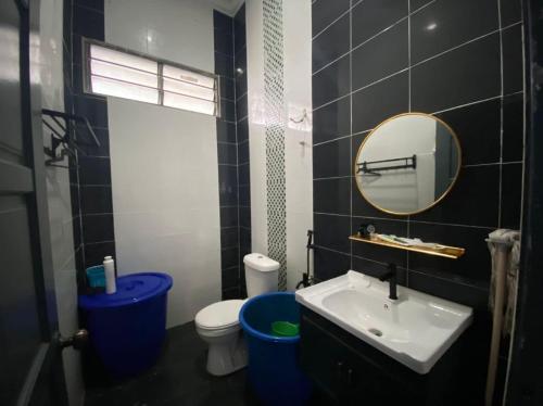 La salle de bains est pourvue d'un lavabo, de toilettes et d'un miroir. dans l'établissement homestay kuala kedah, à Kuala Kedah