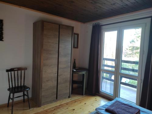 a bedroom with a cupboard and a sliding glass door at Kenderhordó Pihenőház in Zánka