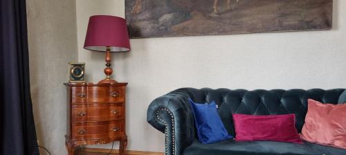 a living room with a couch with pillows and a lamp at Drachenburg in Marktbreit