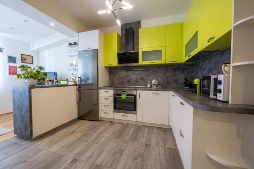 una cucina con armadi gialli e bianchi e pavimenti in legno di Julie Suite Top Center a Sofia