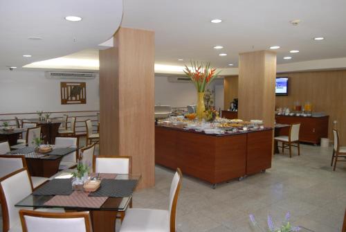 a restaurant with tables and chairs and a buffet at Bristol Jangada Fortaleza Meirelles in Fortaleza