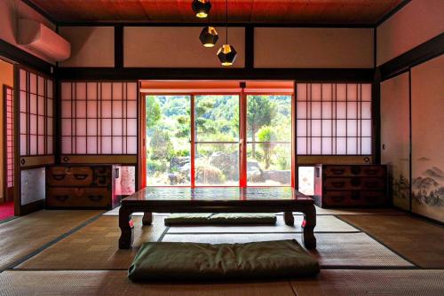 a room with a table and a large window at くらやしき〜kurayashiki~ in Kami-ikusaka