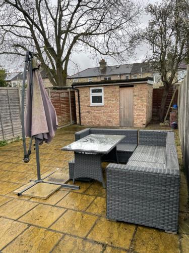 a patio with an umbrella and a table and chairs at Amazing Garden Studio 1 - Chingford/NE London in London