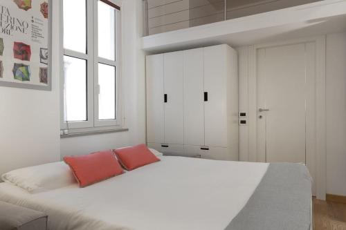 1 dormitorio blanco con 1 cama grande y 2 almohadas rojas en Apartments Trieste Centro I Imbriani 12/B, en Trieste