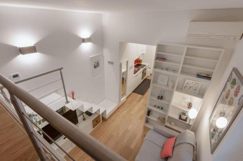 Habitación blanca con escalera y sofá en Apartments Trieste Centro I Imbriani 12/B, en Trieste