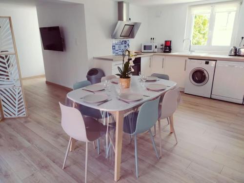 a dining room table with chairs and a kitchen at T3 - Appartement jardin Wissant 6 personnes in Wissant