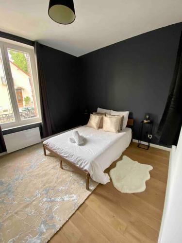 - une chambre avec un lit blanc et un mur noir dans l'établissement Centre de Vichy avec terrasse, à Vichy