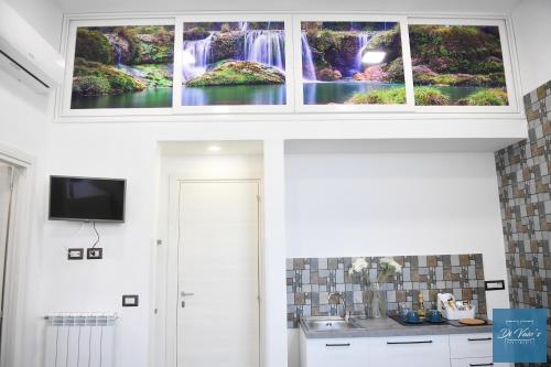 a kitchen with a waterfall painting on the wall at Di Vaio’s Apartments in Naples