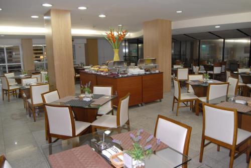 a restaurant with tables and chairs and a buffet at Bristol Jangada Fortaleza Meirelles in Fortaleza