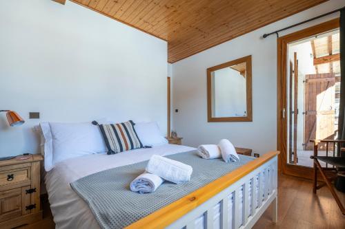 une chambre avec un lit avec des serviettes dessus dans l'établissement Chalet Les Cyclamens, aux Gets