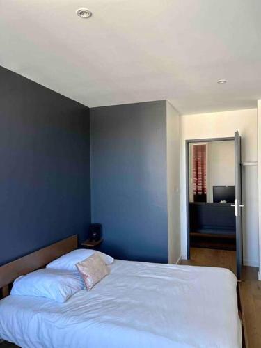 une chambre avec un lit avec un mur bleu dans l'établissement Appartement 40m2 centre de Vichy, à Vichy