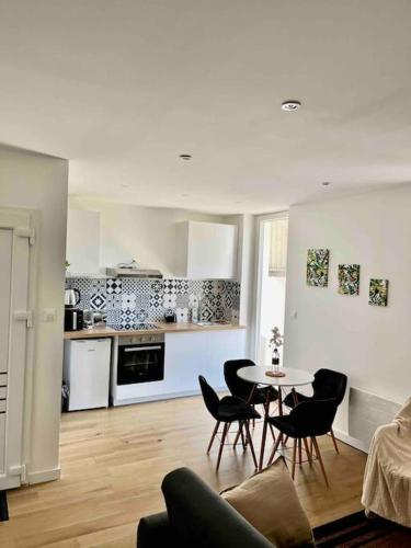 un salon avec une table et des chaises et une cuisine dans l'établissement Appartement 40m2 centre de Vichy, à Vichy