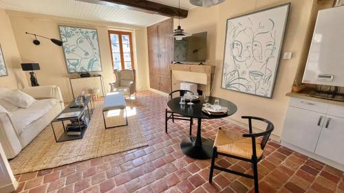 een woonkamer met een tafel en een bank bij La Dolce Vita in Beaune