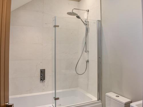 W łazience znajduje się prysznic ze szklanymi drzwiami. w obiekcie Striding Edge Cottage w mieście Glenridding