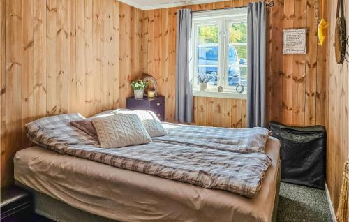 a bed in a wooden room with a window at Awesome Home In Hjartdal With Kitchen in Hjartdal