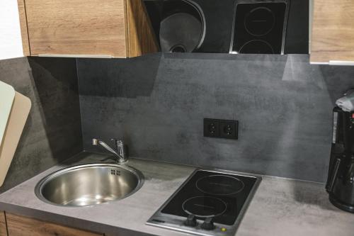 a kitchen counter with a sink and a stove at Landhaus Perktold in Nesselwängle