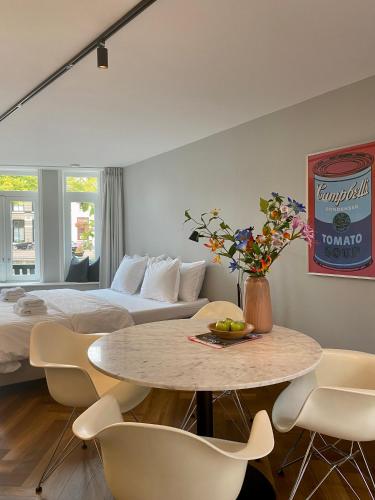 een hotelkamer met een bed en een tafel en stoelen bij Studio 157, in de stad aan de gracht in Kampen