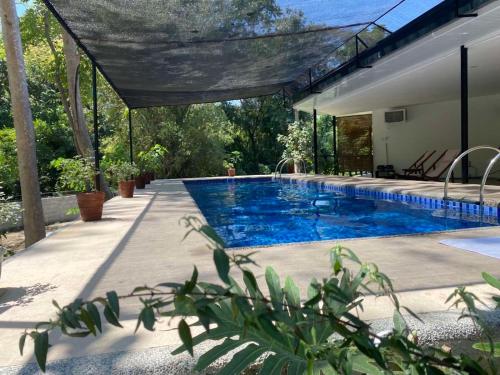 a swimming pool in the backyard of a house at Balai Benedicere Bed & Breakfast in Bacnotan