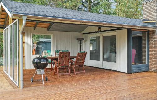 a patio with a grill and a table on a deck at 3 Bedroom Lovely Home In Thyholm in Thyholm