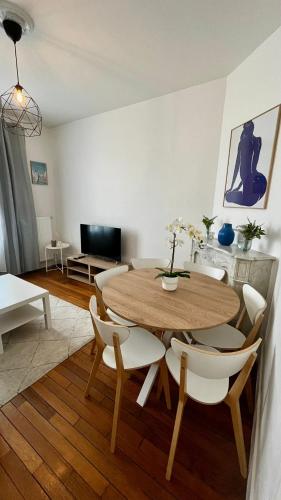 un salon avec une table et des chaises en bois dans l'établissement VILLEMOMBLE 2 centre ville, à Villemomble