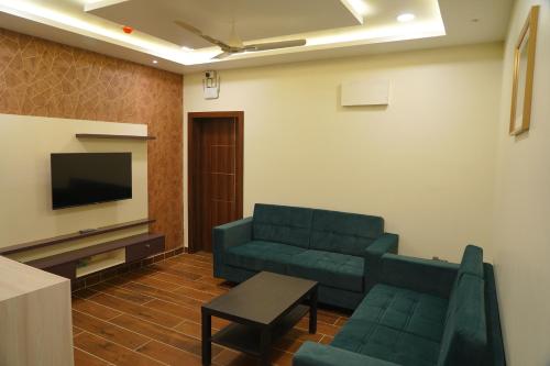 a living room with a couch and a tv at Mevid Hotels in Hyderabad