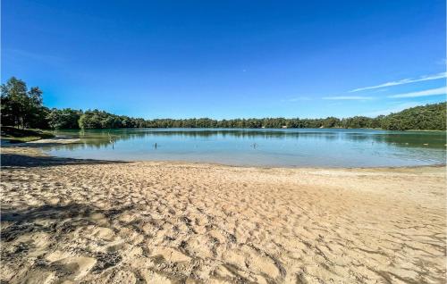 a beach with a body of water with trees in the background at Stunning StaCaravan In Hoogersmilde in Hoogersmilde